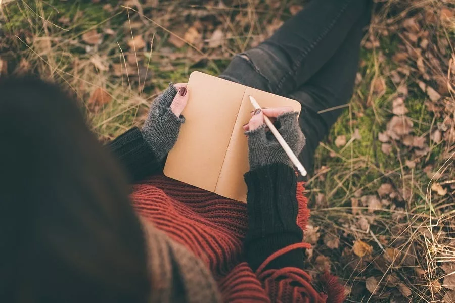 Woman writing in nature.