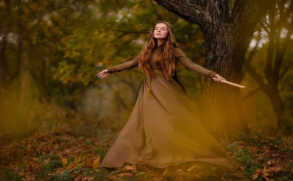 Woman in dress walking in fantasy fairy tale forest