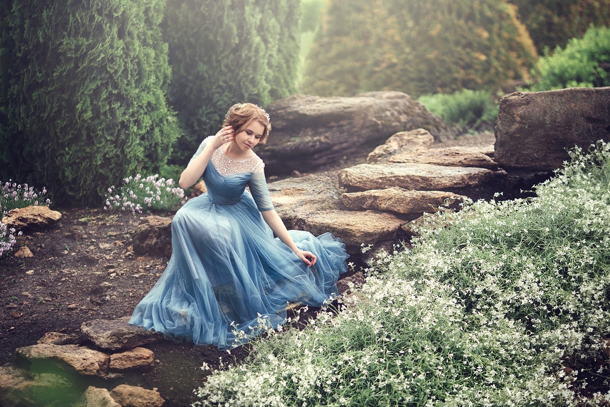 A beautiful young lady in a blue dress walking in the garden