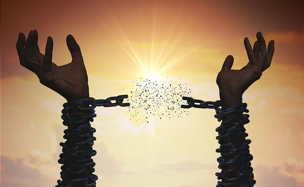 Silhouettes of hands are breaking chain. Freedom concept.