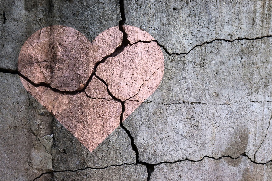 Drawing of a pink heart on a cracked wall. 