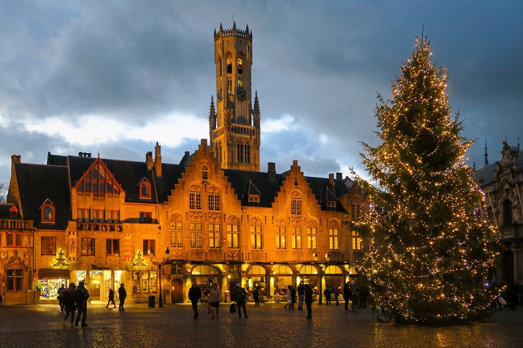City hall and basilica at christmas with decorations at night in Bruges, Belgium.