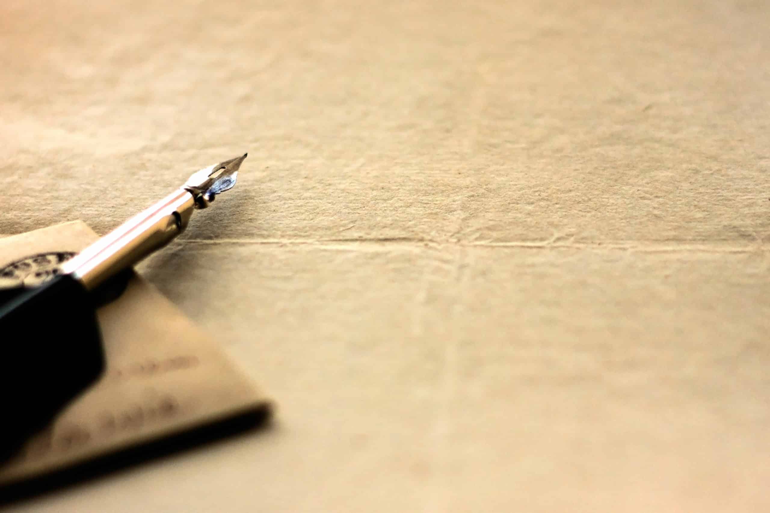 Quill pen and blank sheet of vintage paper.