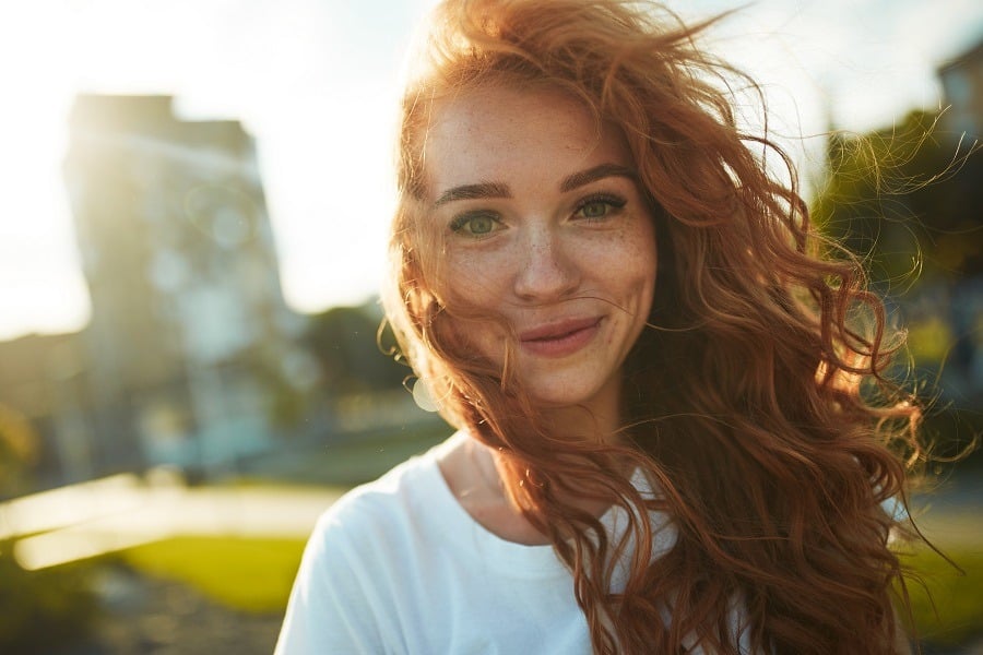 A charming red-haired girl with a cute lovely smile.