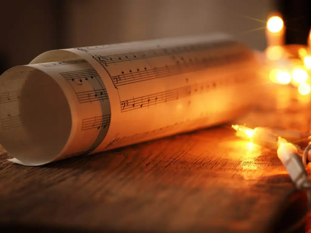 Rolled music sheet with yellow lights in background.