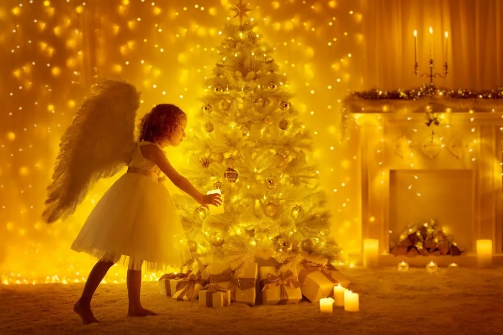 Golden Christmas and a girl angel lighting a candle.