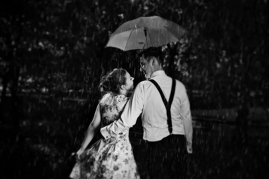 Young romantic couple in love flirting in rain.