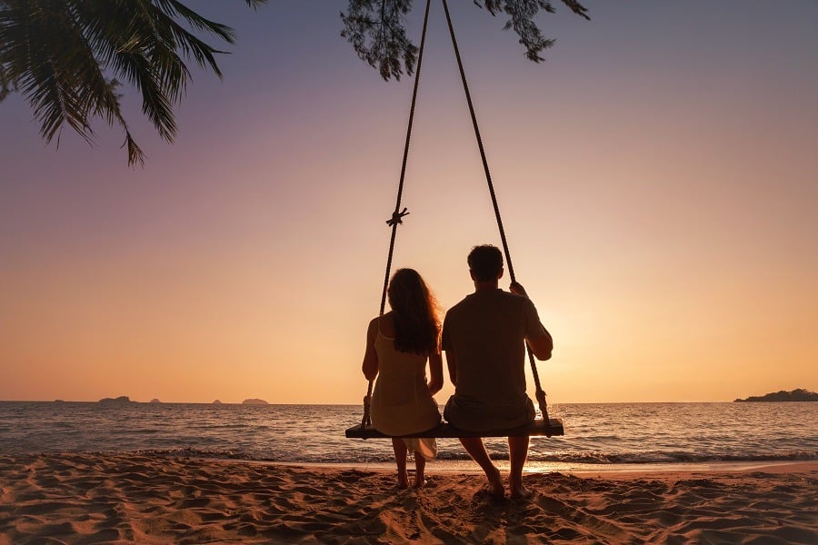 Silhouette of romantic couple on sunset beach, tropical holidays near the sea.