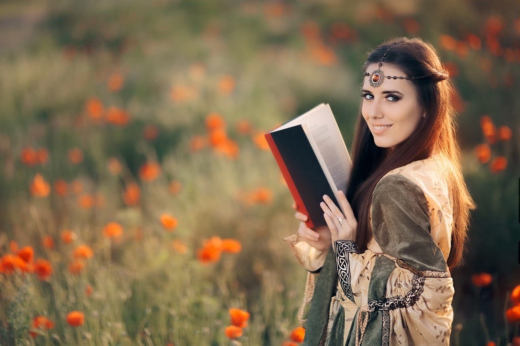 Medieval woman reading a book in a magical field of poppies.