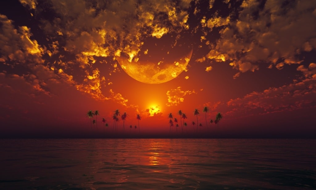 Big moon in clouds over red sunset at tropical sea.