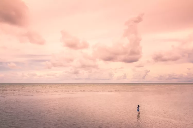 Girl standing in the sea in a lonely atmosphere.