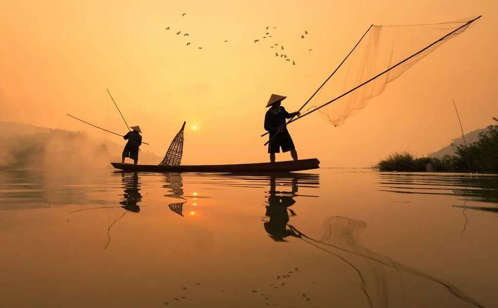 Fisherman is fishing with his son in the morning