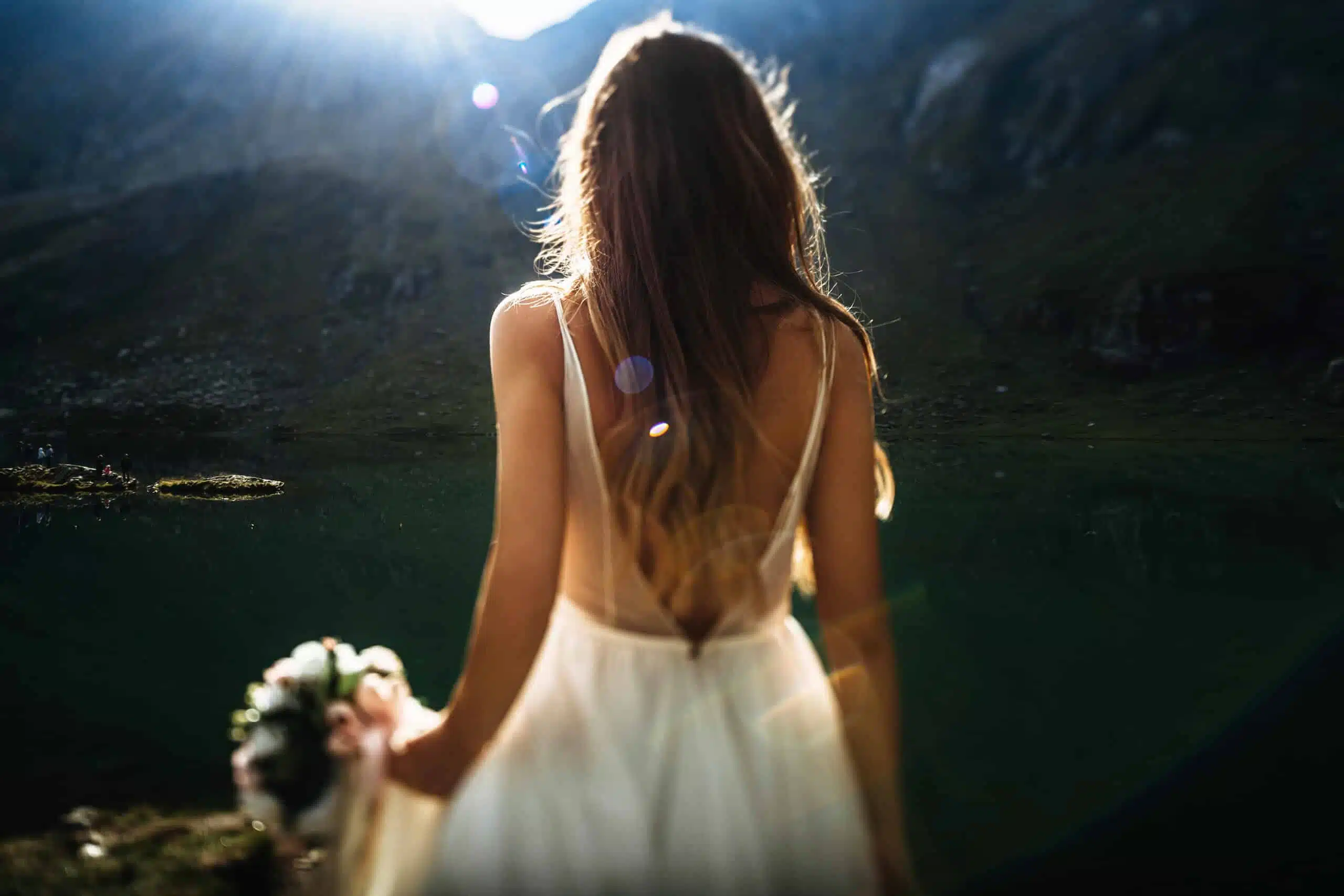 Unrecognizable back view of a young long haired bride walking ag
