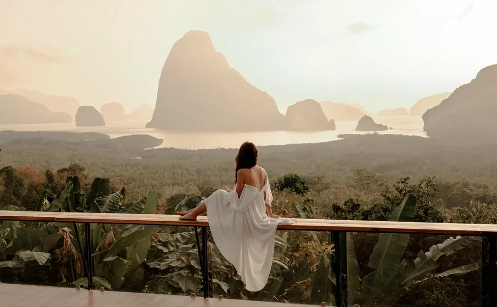 Woman with the white dress sit and watching the mountain