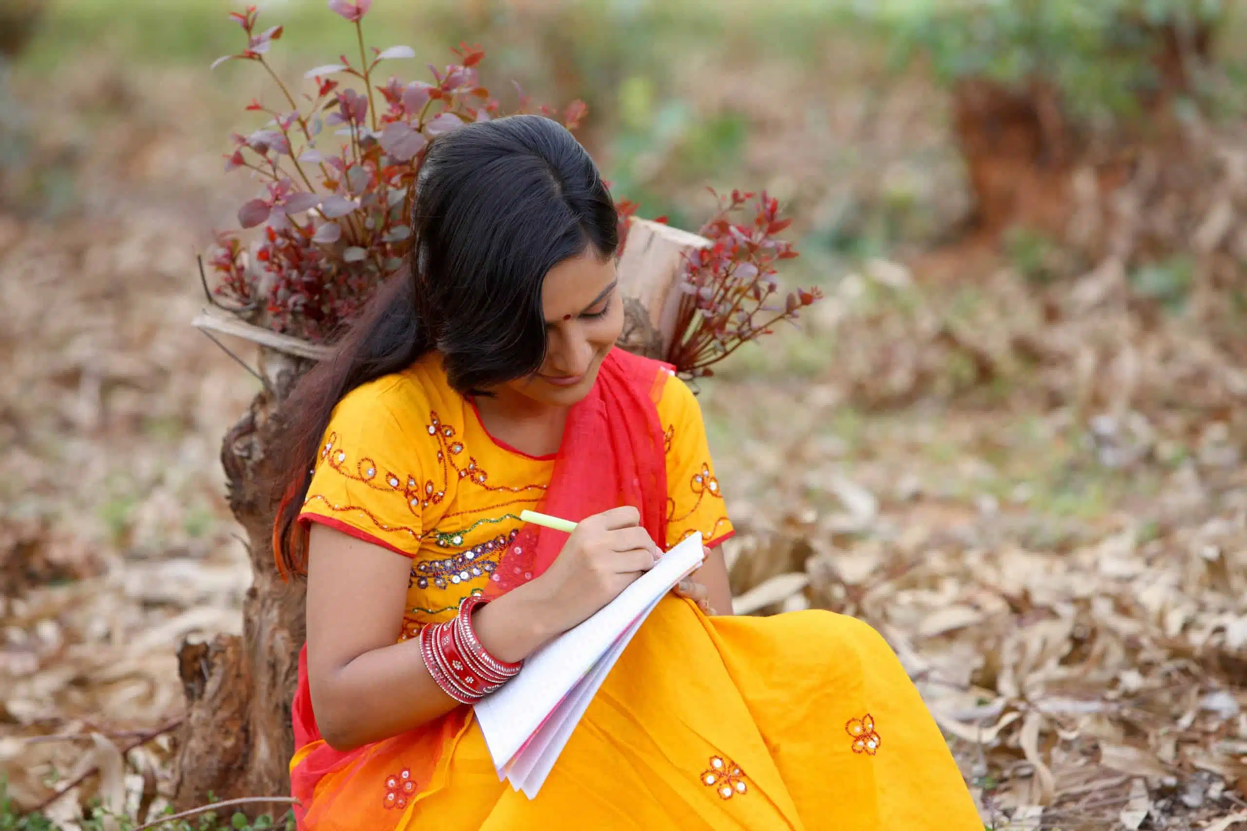 Indian woman in Sari writing outdoor