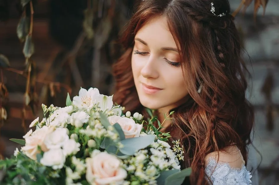 Face of a beautiful bride with fresh wedding bouquet.