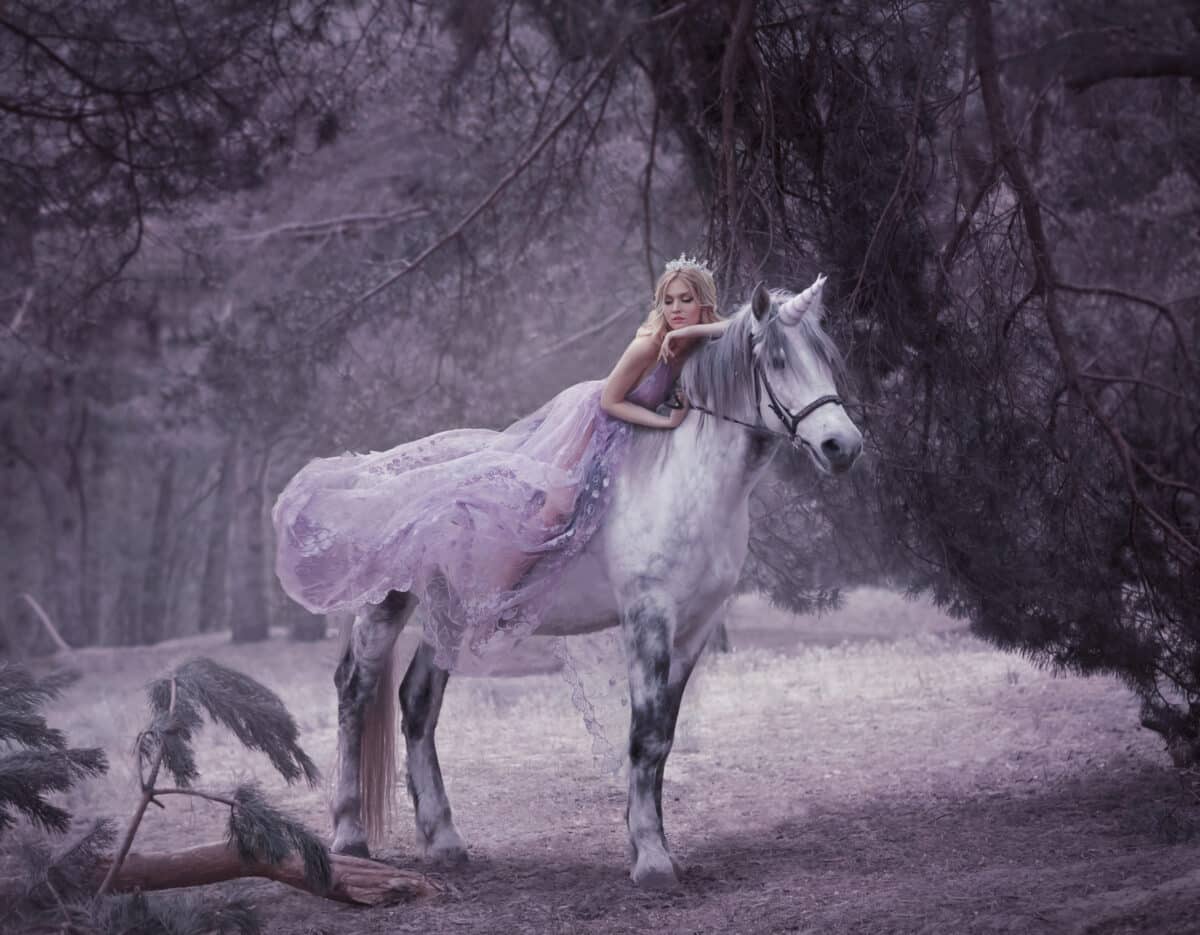 a fairy in a purple dress lying on the horse's back in the woods