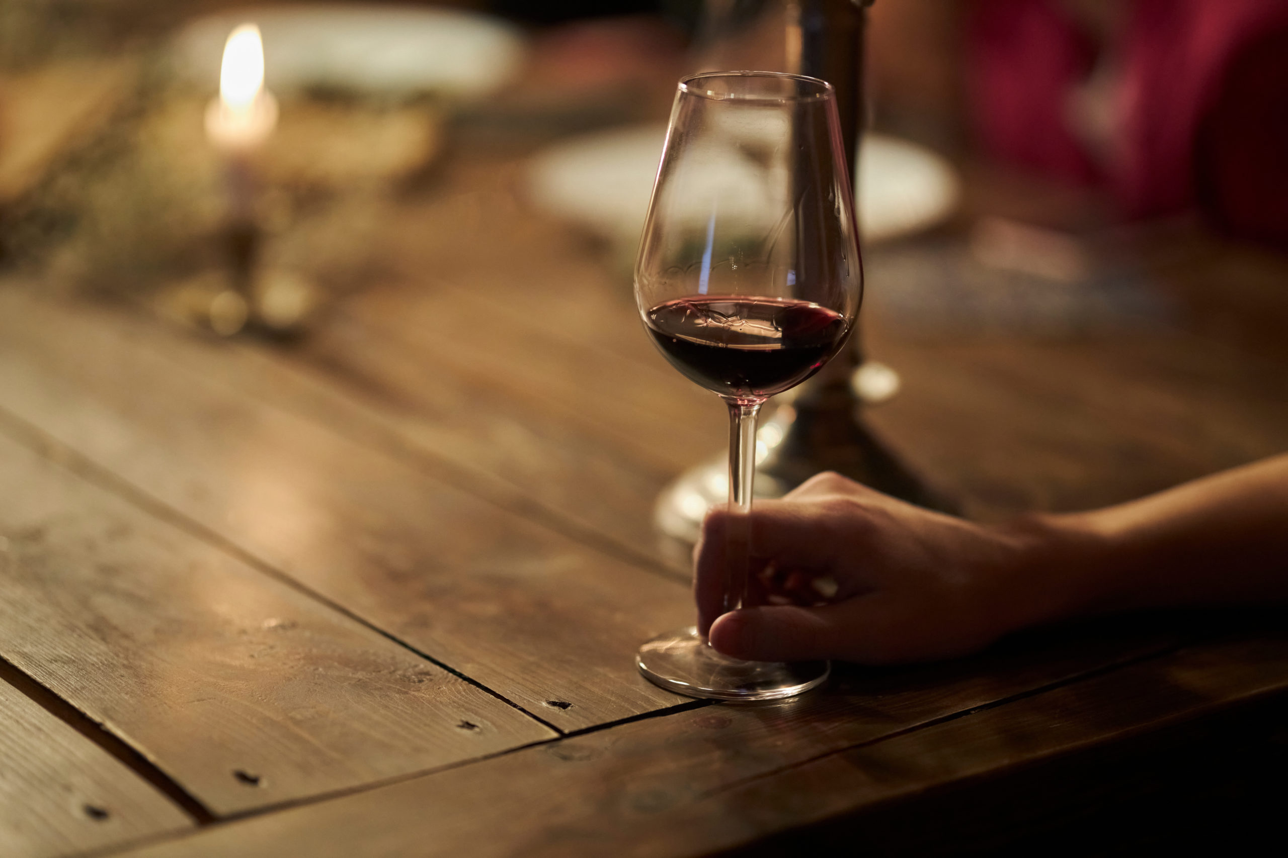 Woman holds a glass of red wine in her hand,