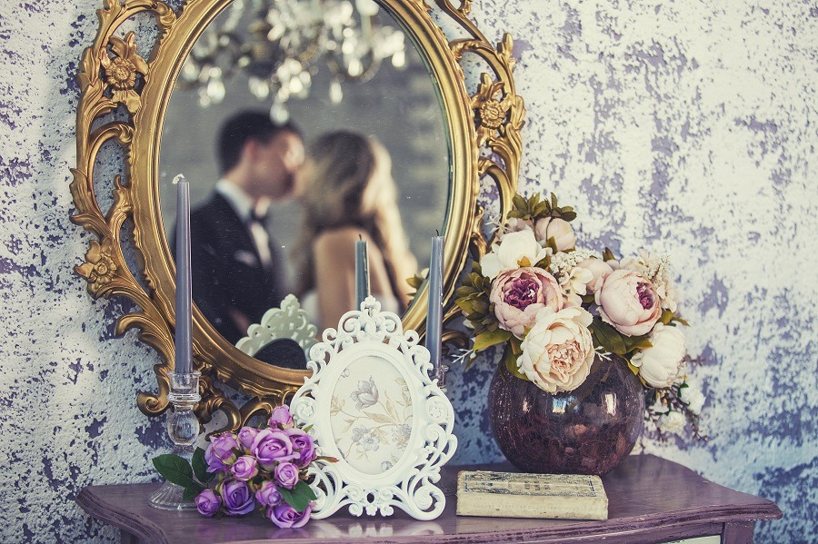 Vintage mirror with kissing bride and groom in the reflection.