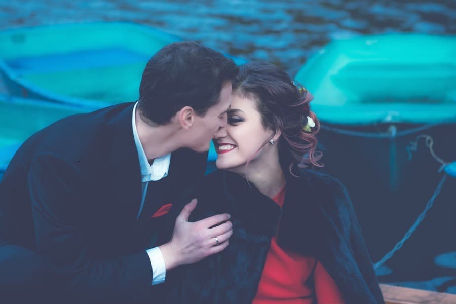 Romantic couple on a boat faces very close.