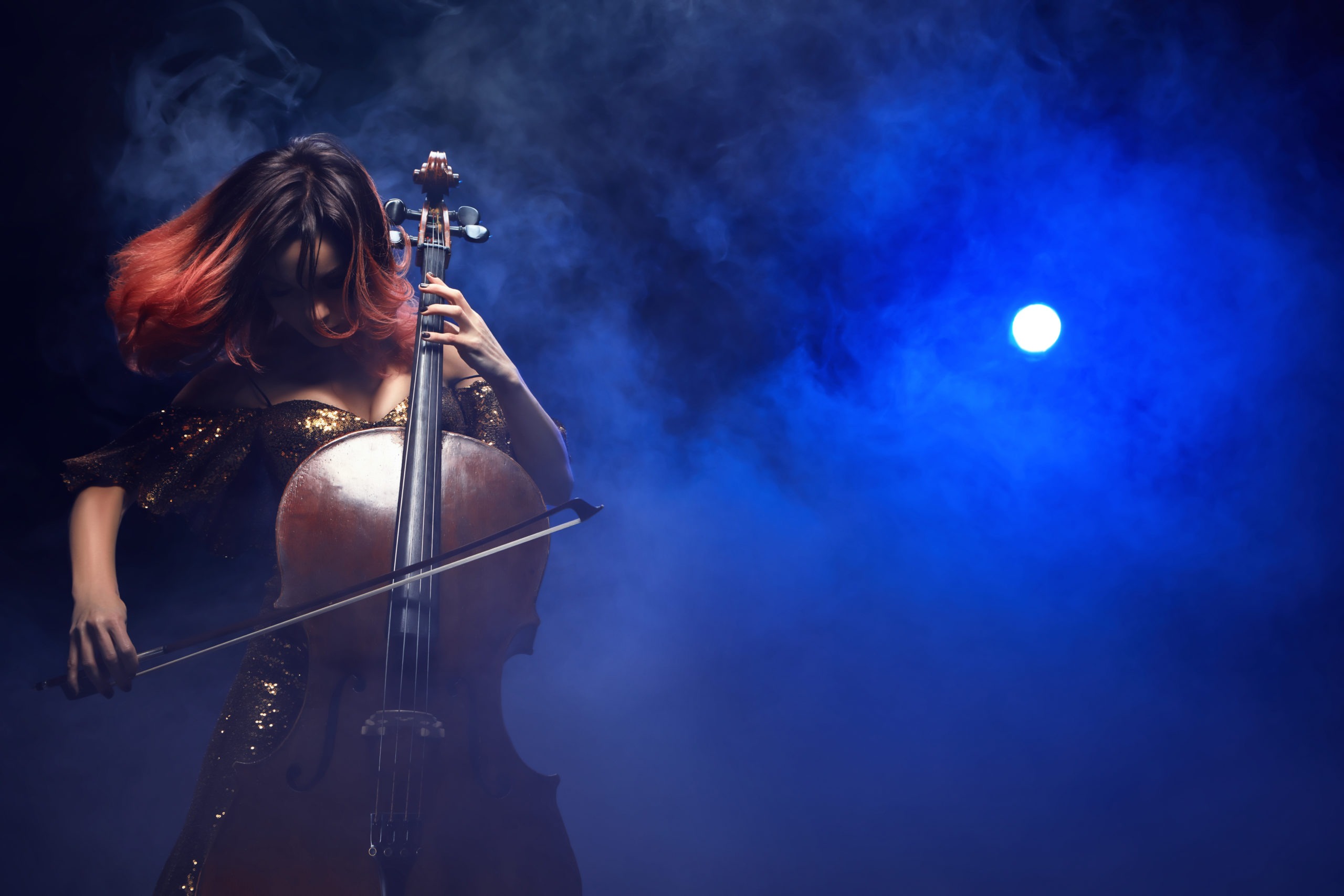 Female cellist performs on stage.
