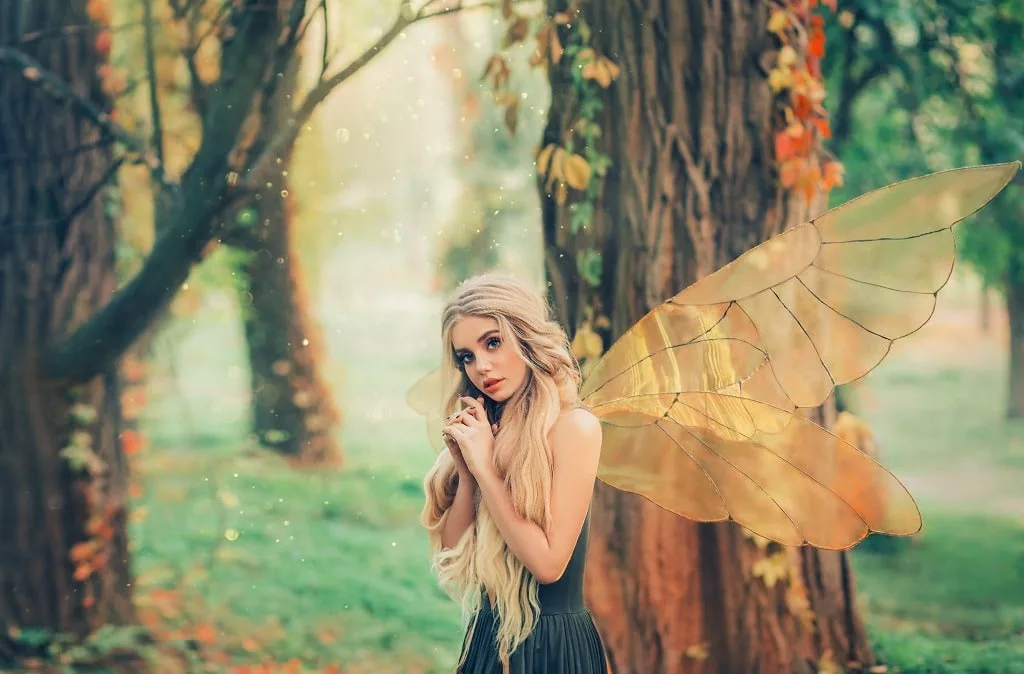 Mysterious forest fairy with blond long hair and blue eyes.