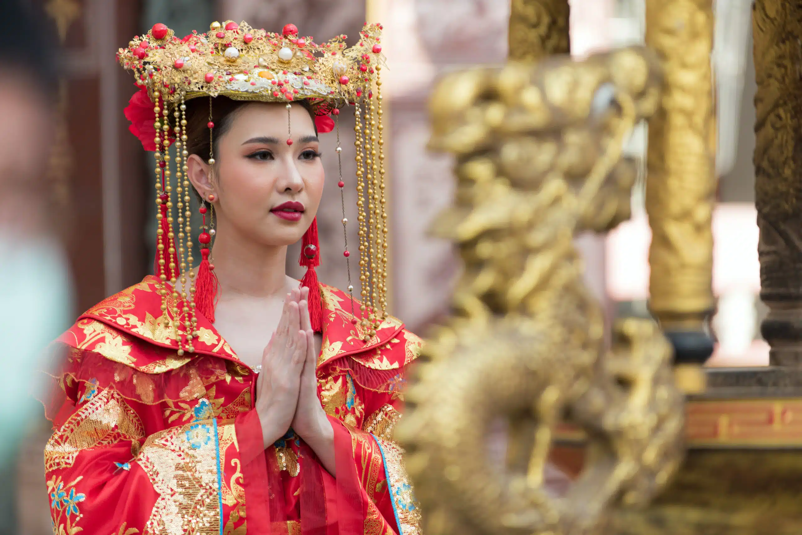 beautiful Asian woman wearing traditional Chinese clothing is paying homage to deity