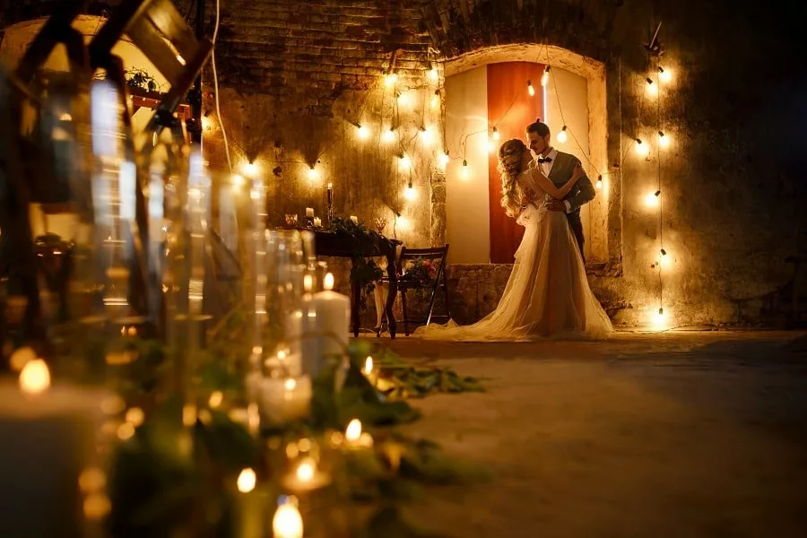 Stylish wedding couple in romantic loft decorations at night.