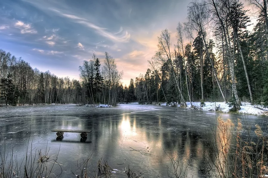 Glassy frozen lake on a lonely winter evening.