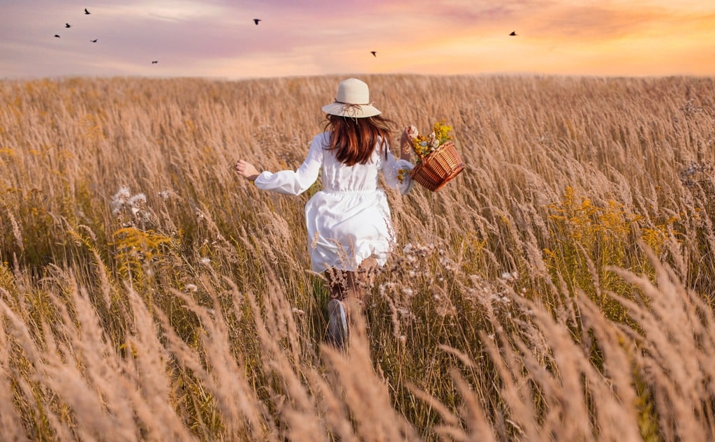 Girl with hat running on the meadow