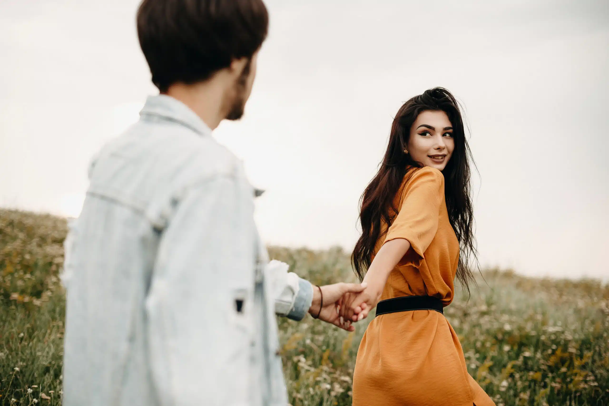 Beautiful charming woman holding hand of her boyfriend leading him