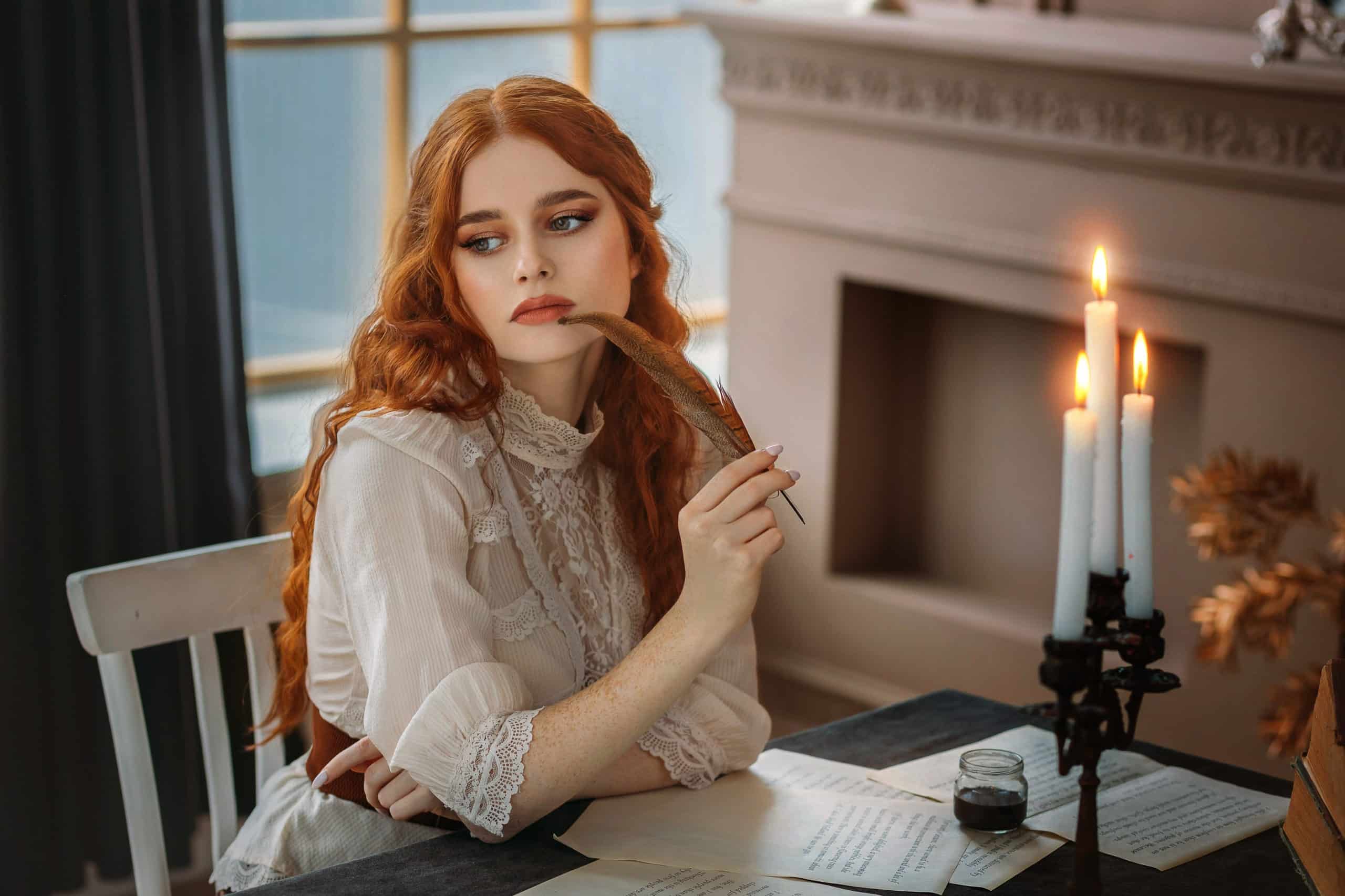Medieval redhead lady sits at table writes with quill pen and vintage paper.