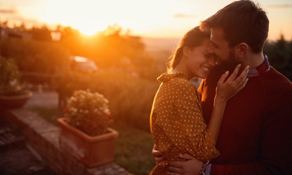 Romantic young couple hugging and enjoying the sunset.