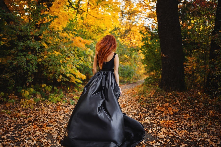 Woman long hair running to orange forest in autumn.