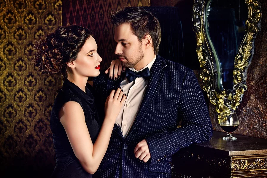 Beautiful man and woman in elegant evening vintage clothes standing close with intense desire for each other.