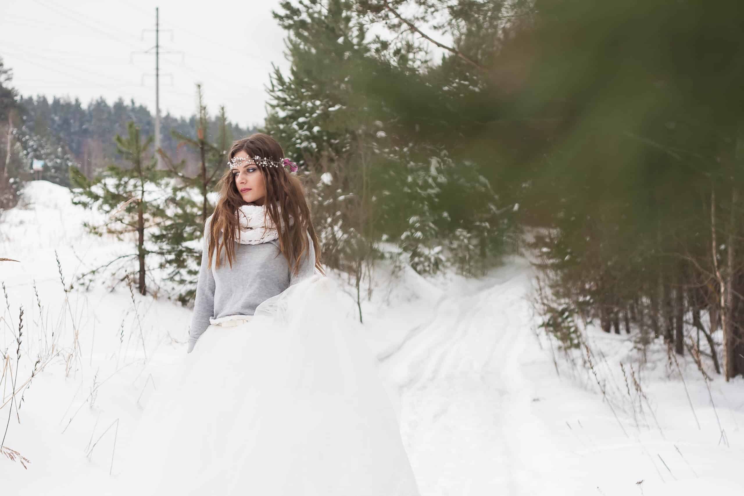 beautiful fairy-like woman in snow covered forest.