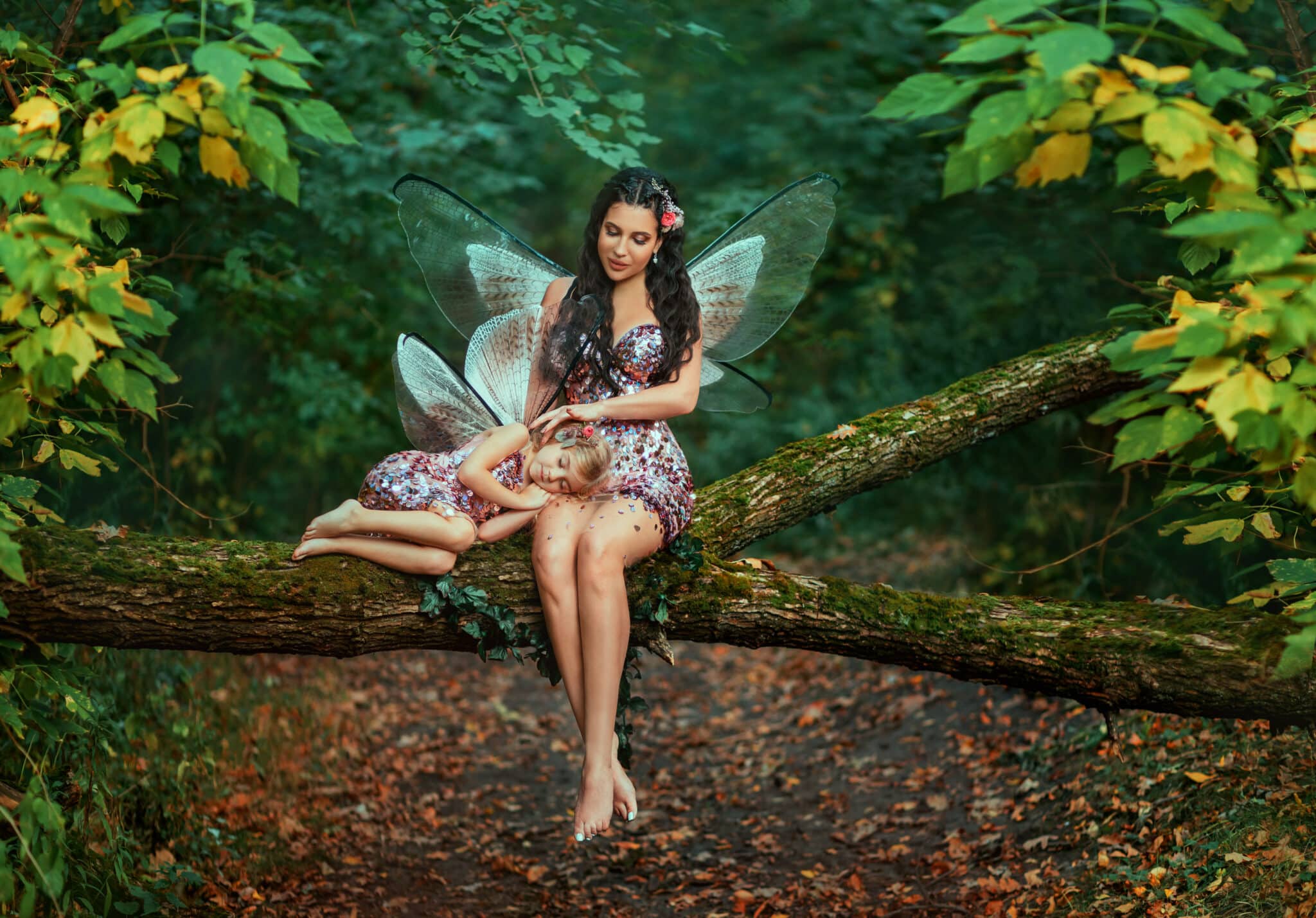 Fantasy woman fairy, sitting on log stroking with love sleeping little girl. Pixie is dreaming. Mom reads fairy tale to daughter, sings lullaby.