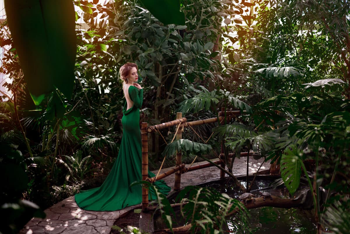 Beautiful woman in a green long dress in the tropics