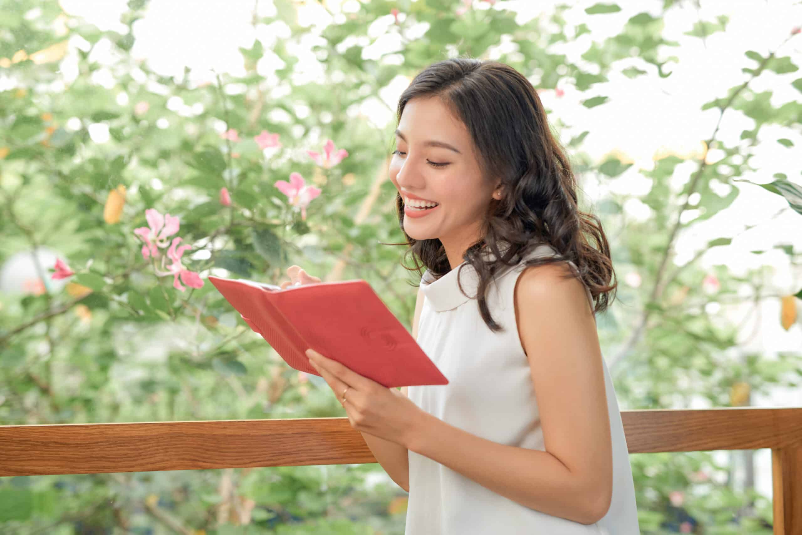 young beautiful asian woman relax holding book in coffee shop