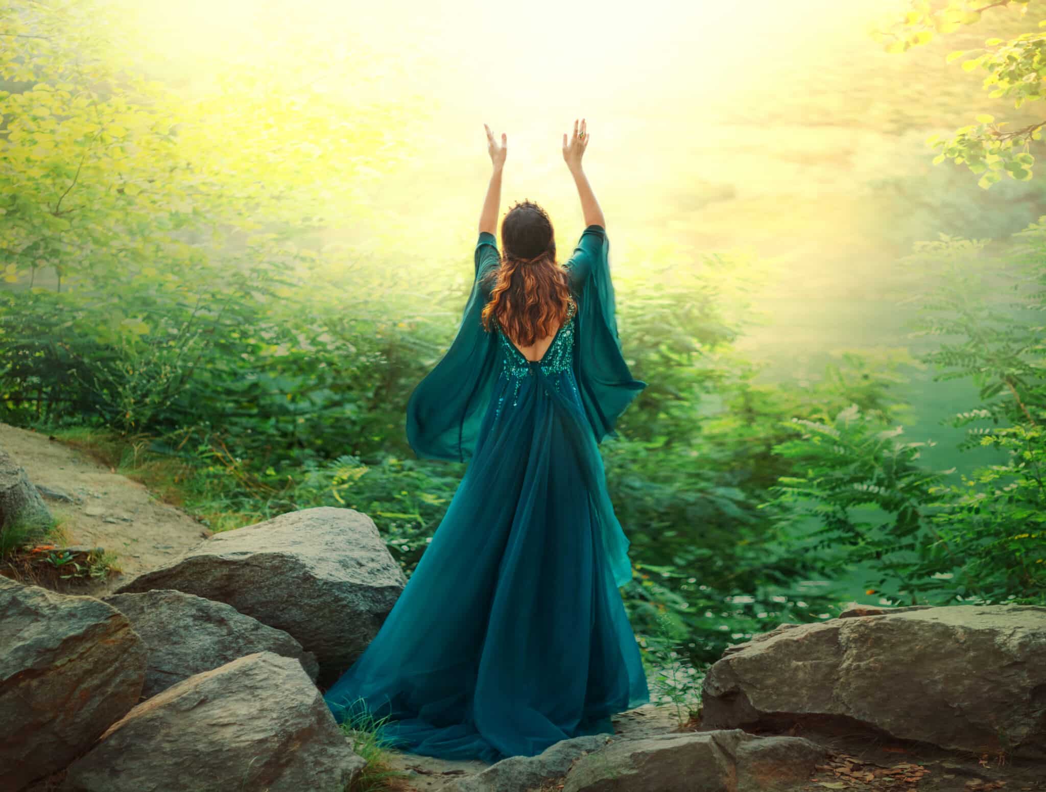 Fantasy woman queen prays in summer forest hands raised to divine magical sun light sky.
