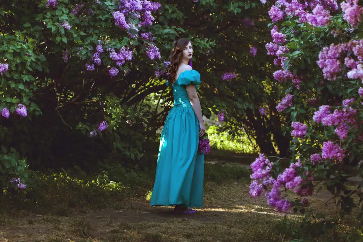 Woman is walking in the garden of lilac.