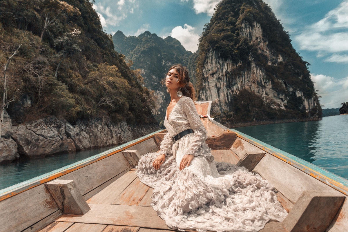 fashionable young model in elegant dress on boat at the lake.