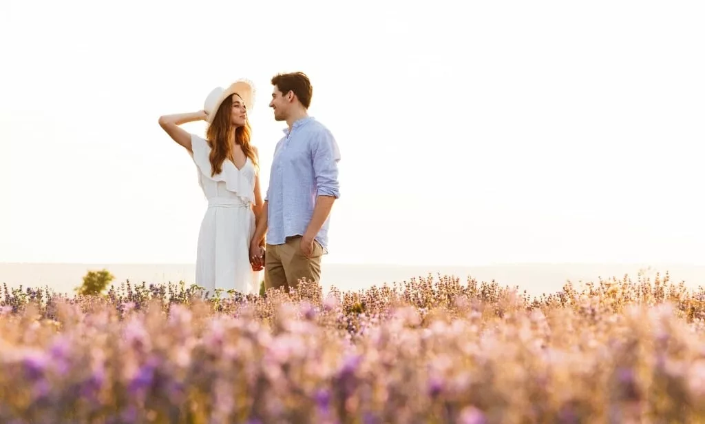 Sweet couple having fun in the field of lavender flowers.