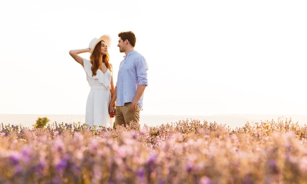 Sweet couple having fun in the field of lavender flowers.
