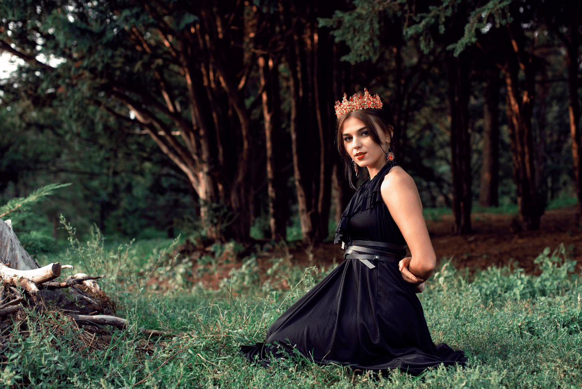 slender brunette in a black dress in the park
