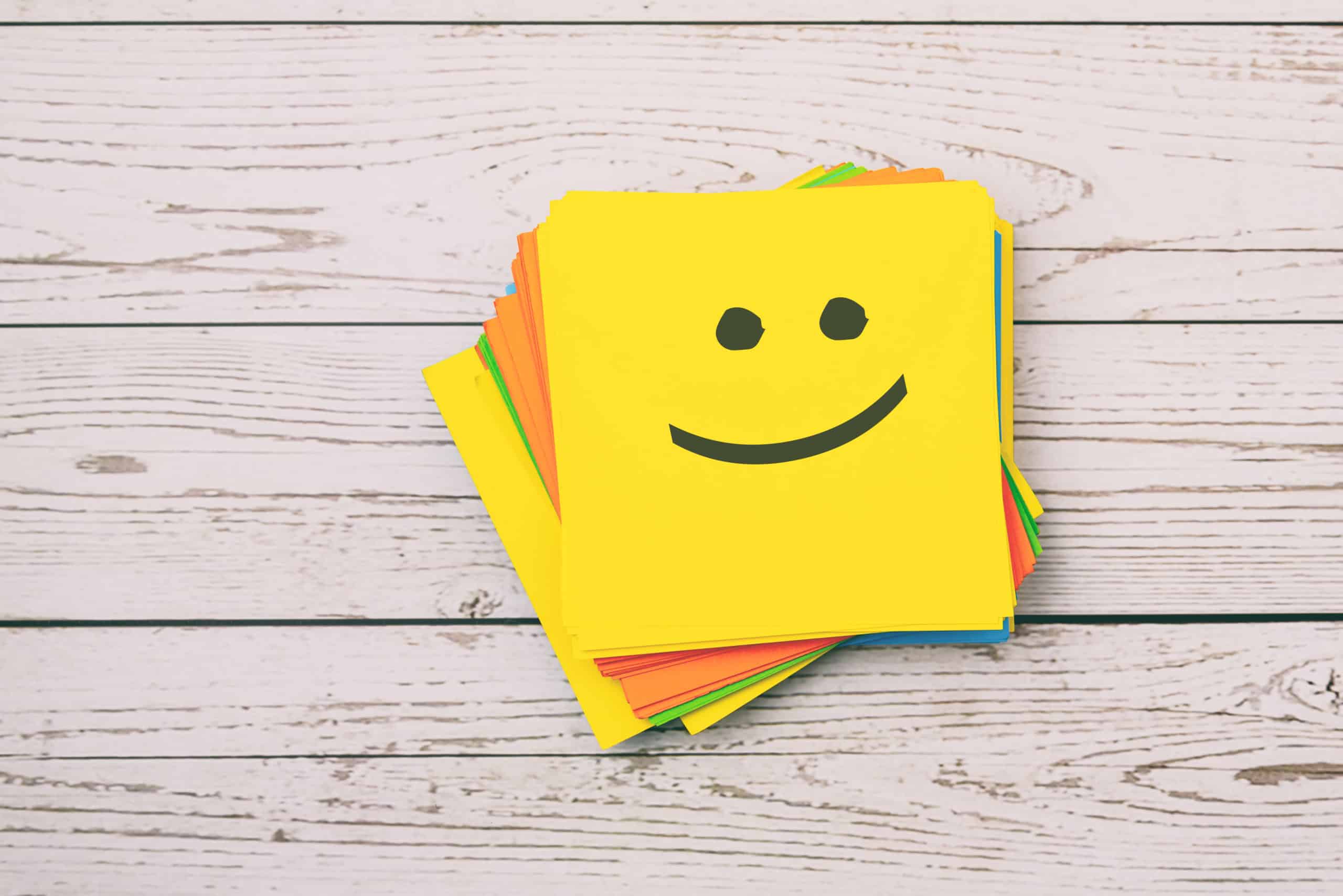 Happy emoticon on yellow paper note