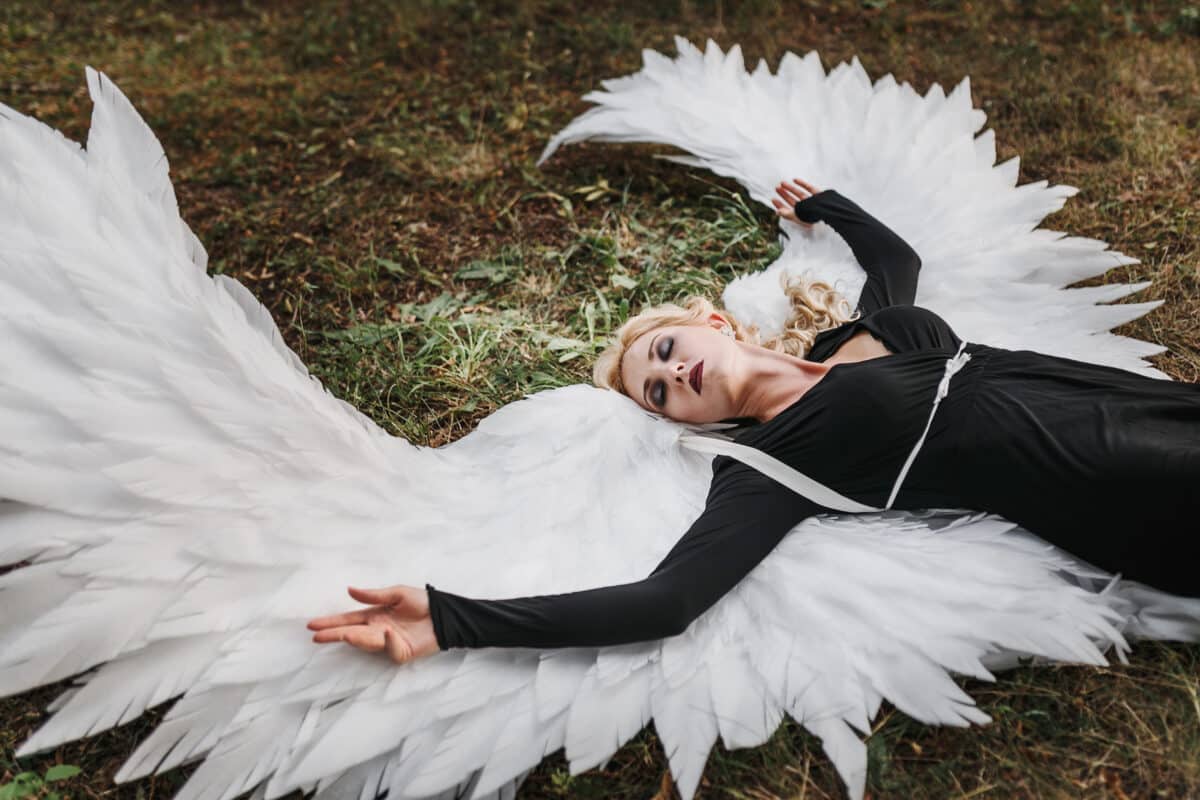 Dark fallen angel lying on the ground. 