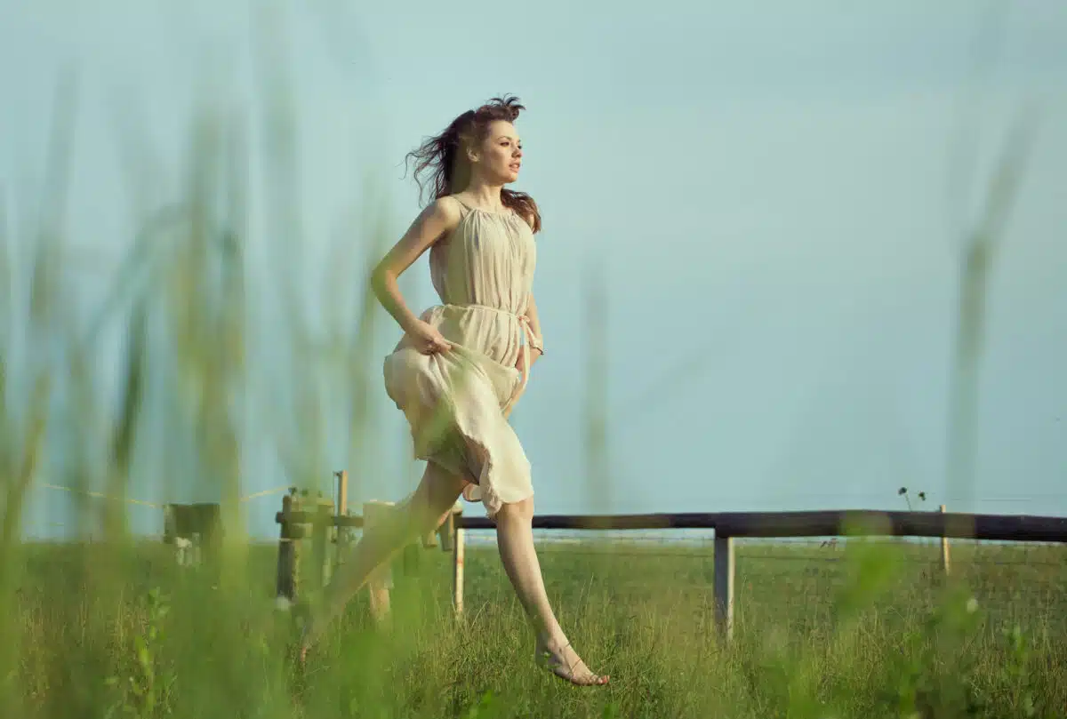 Delicate lady running on the meadow
