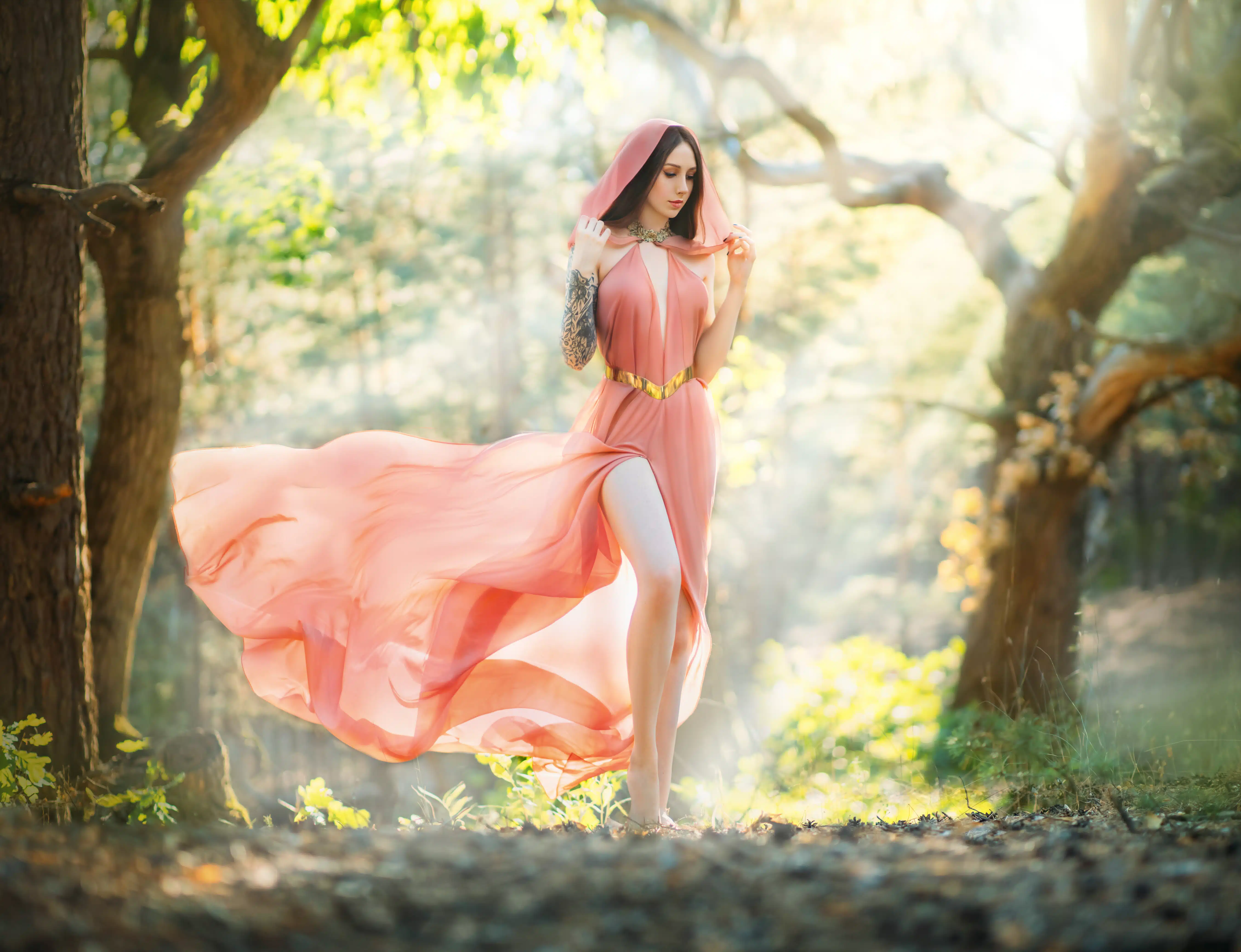 Young beautiful woman fantasy elf walks in spring forest. Green trees background, summer park.