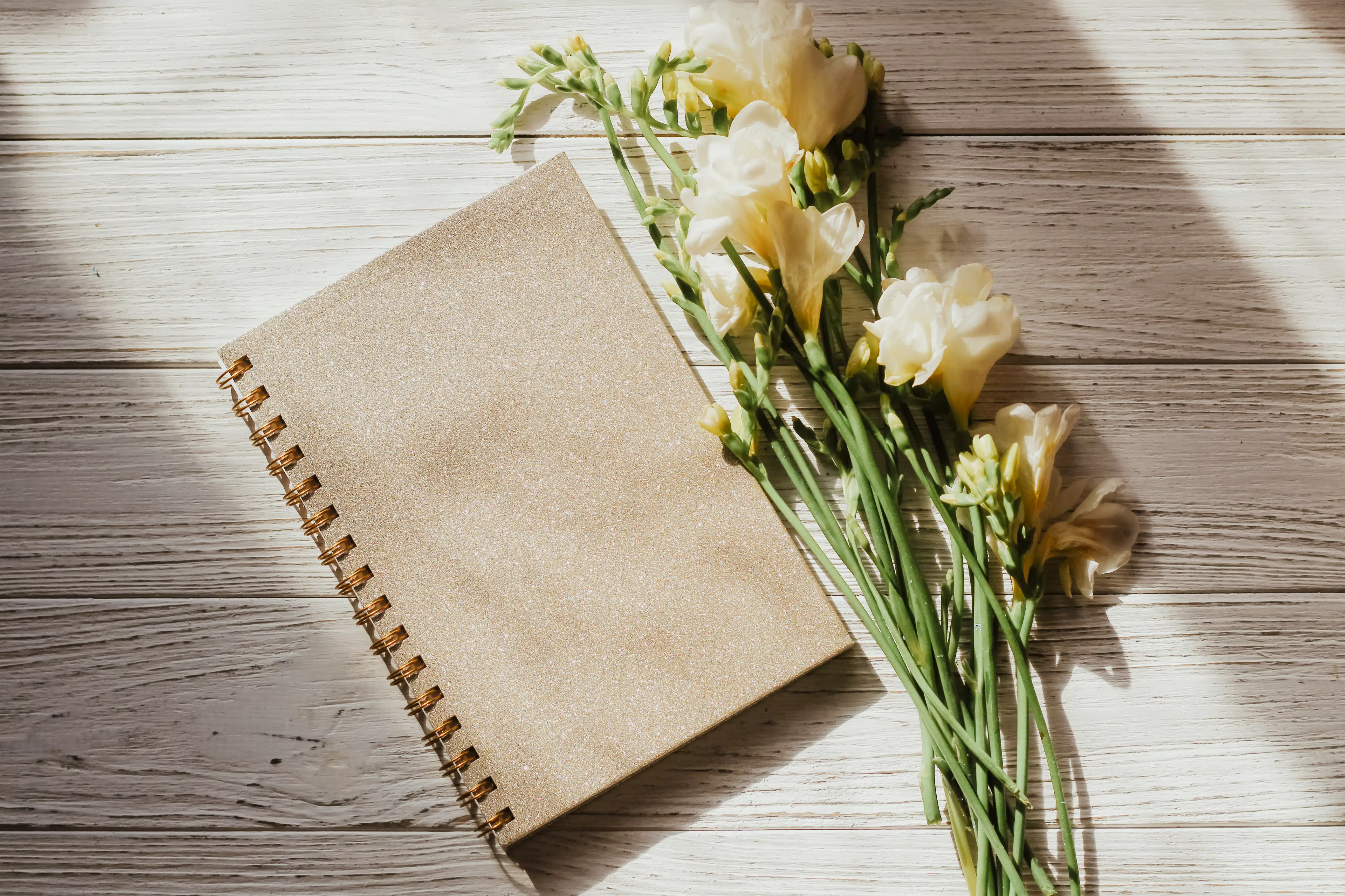Diary notebook on the background of flowers and wooden figured boards